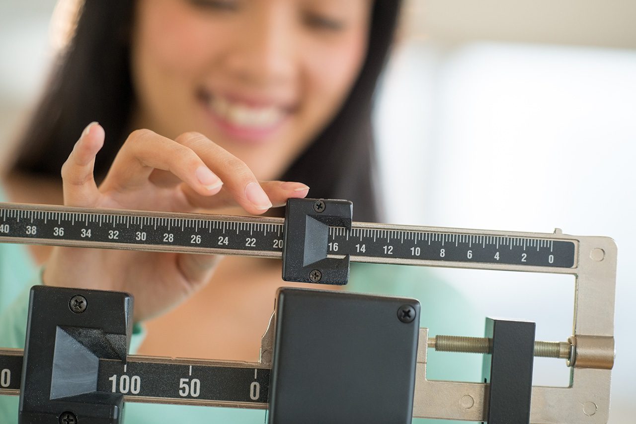 Woman checking her weight Woman checking her weight